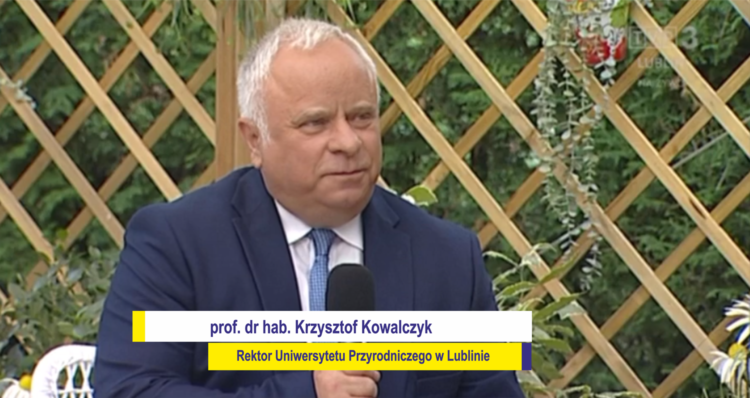 wywiad z Rektorem Uniwersytetu Przyrodniczego w Lublinie, mikrofon w ręce, w tle altana ogrodowa
