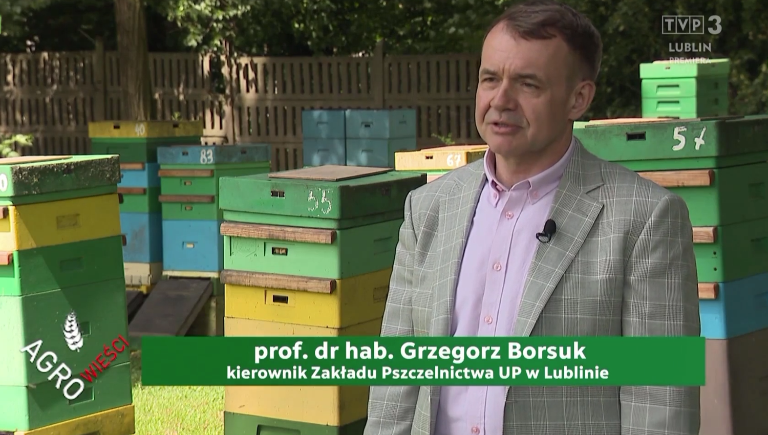 Prof. Grzegorz Borsuk w szarym garniturze stoi nas tle uli