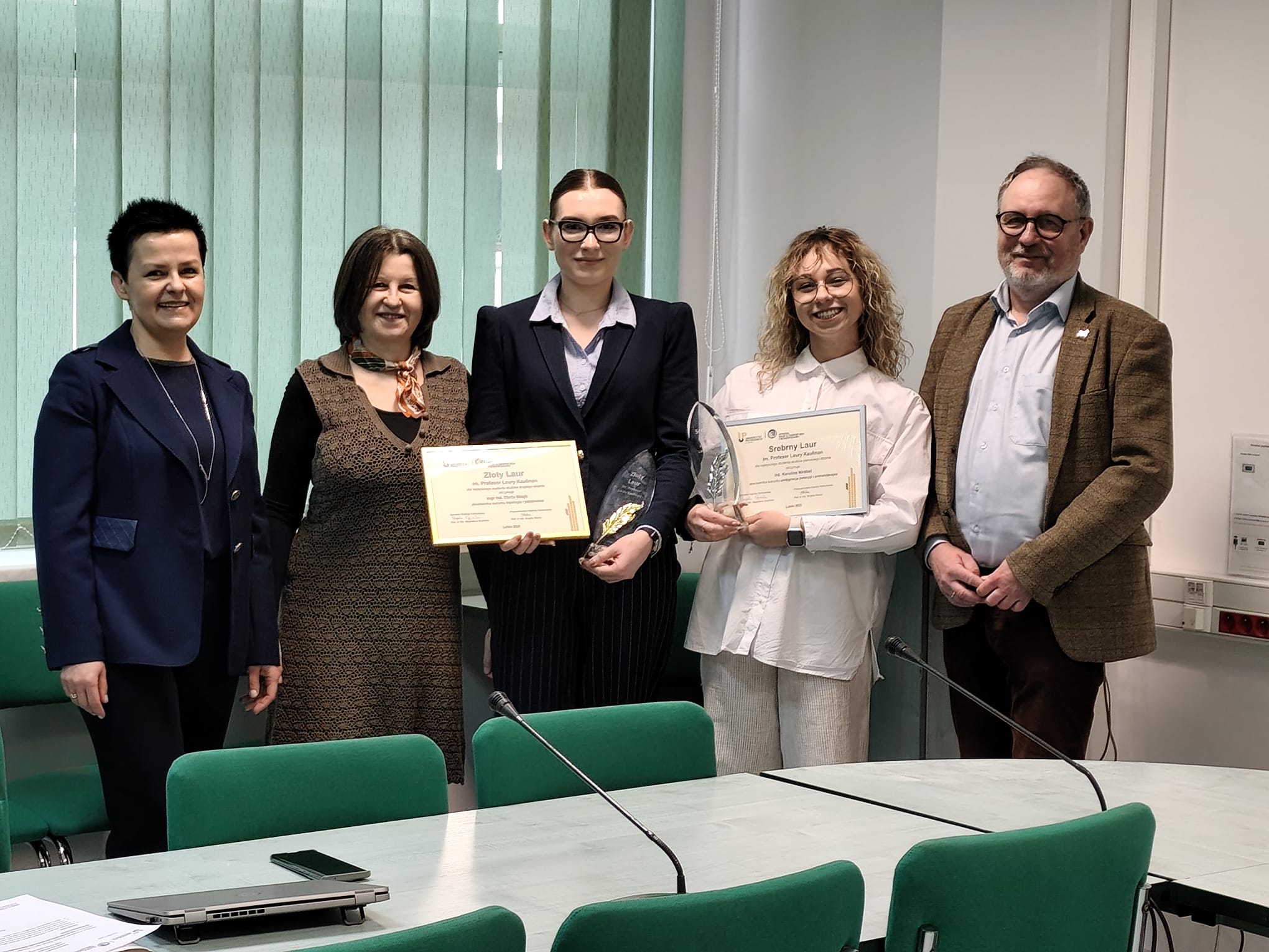 prof. Brygida Ślaska - granatowe spodium i&nbsp;prof. Andrzej Junkuszew - brązowy garnitur z&nbsp;laureatkami nagrody