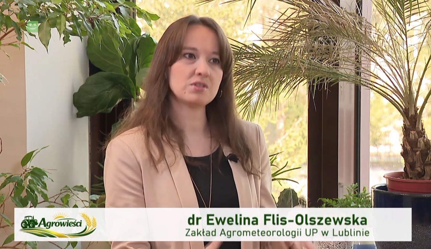 dr Ewelina Flis-Olszewska długie włosy, w&nbsp;beżowym żakiecie, na tle palmy
